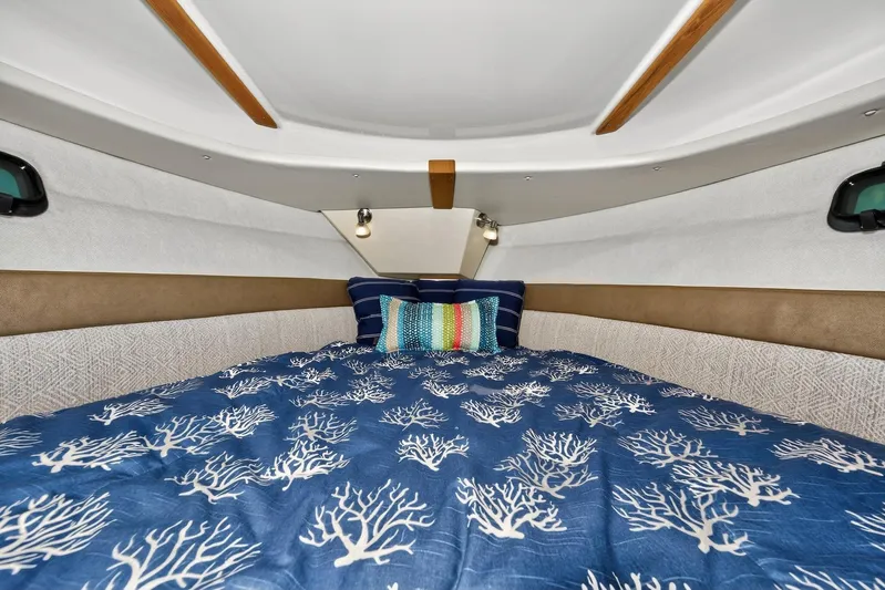  Yacht Photos Pics 2024 Ranger Tugs R-27 cabin interior with cozy bedding and decorative pillows.
