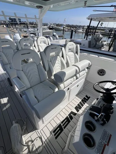 Under Dealer Cost Yacht Photos Pics 2024 Twin Vee 400 Center Console GFX boat interior with white seating at marina.