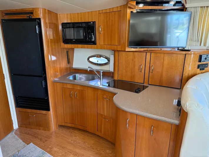  Yacht Photos Pics Interior of 2006 Carver 36 Mariner yacht with kitchenette, TV, and wood cabinetry.