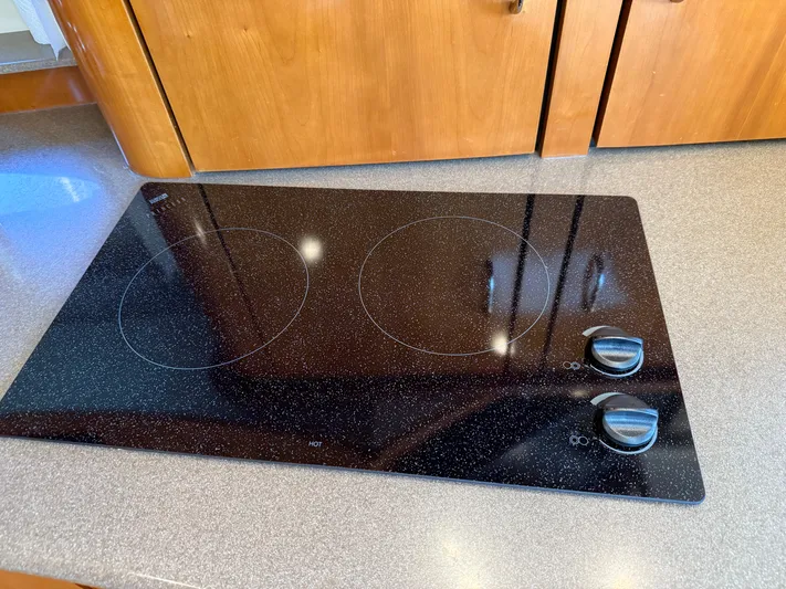  Yacht Photos Pics Stovetop in 2006 Carver 36 Mariner yacht kitchen, featuring two burners and wooden cabinetry.