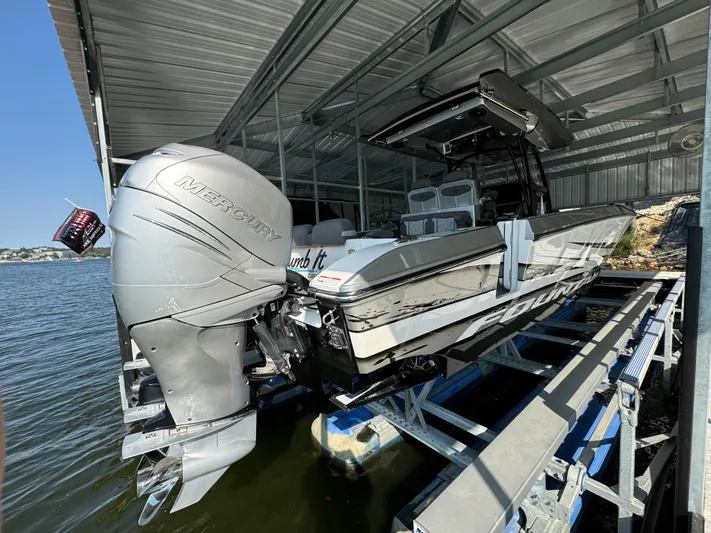  Yacht Photos Pics 2022 Fountain 38 SC boat with Mercury engine docked in a covered marina.