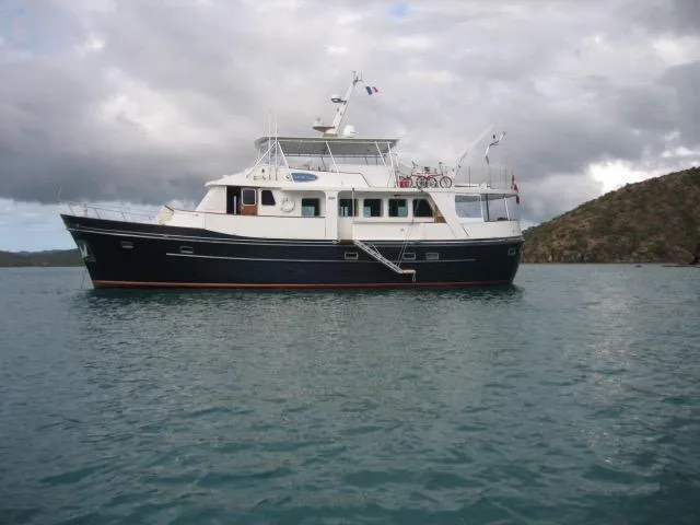 Dame De Coeur Yacht Photos Pics 1982 Cheoy Lee 66 LRC yacht on calm water under cloudy sky.