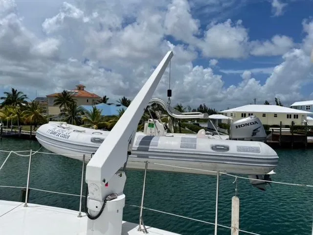 Dame De Coeur Yacht Photos Pics 1982 Cheoy Lee 66 LRC yacht with a mounted inflatable boat, docked near palm trees.