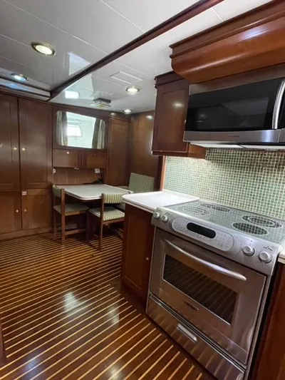 Dame De Coeur Yacht Photos Pics 1982 Cheoy Lee 66 LRC yacht kitchen with wood cabinetry and modern appliances.