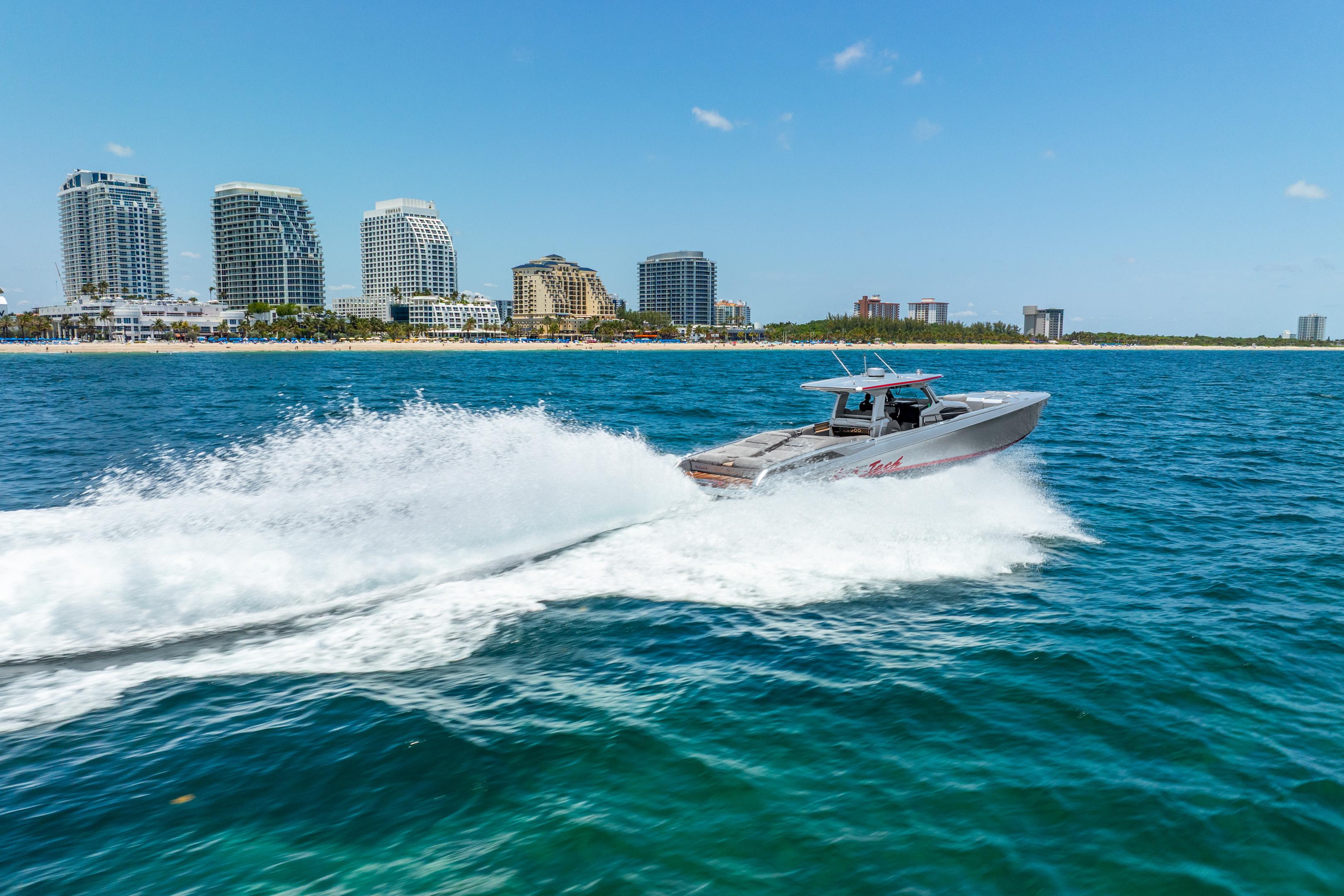 2018 Nor-Tech 560 Sport Center Console cruising near city skyline on blue ocean.