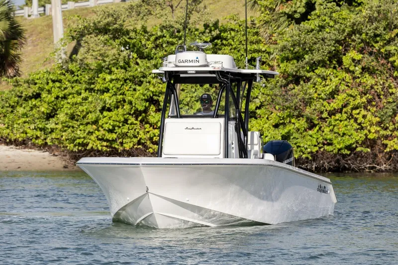  Yacht Photos Pics 2019 SeaHunter 28 Floridian boat cruising on water, surrounded by lush greenery.