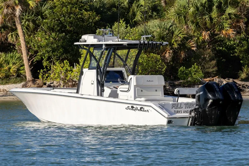  Yacht Photos Pics 2019 SeaHunter 28 Floridian boat on water, surrounded by lush greenery.