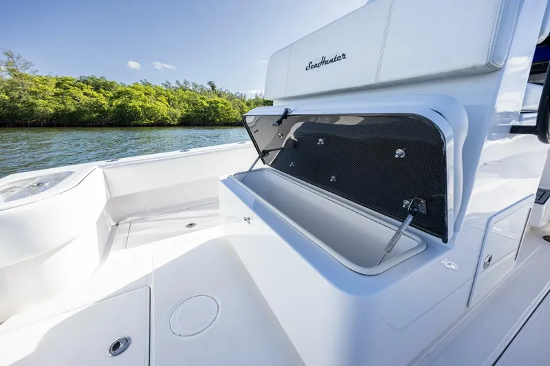  Yacht Photos Pics 2019 SeaHunter 28 Floridian boat with open storage compartment, near lush shoreline.