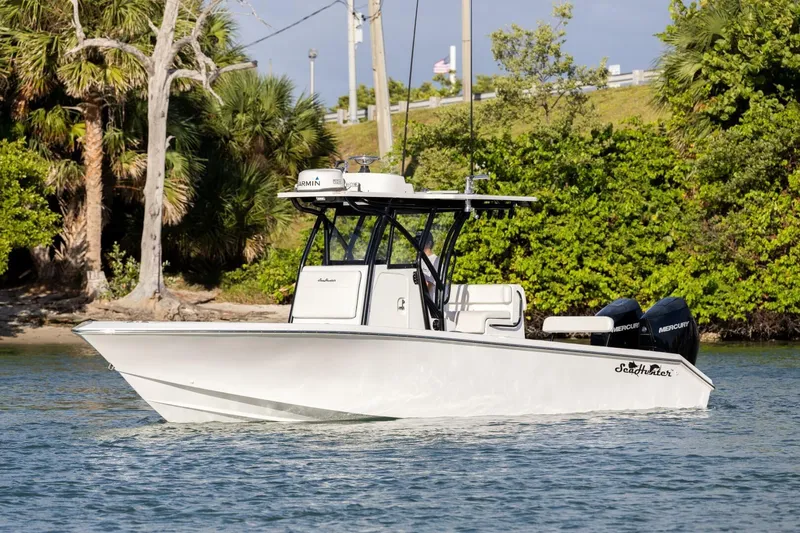  Yacht Photos Pics 2019 SeaHunter 28 Floridian boat cruising on water near lush greenery.