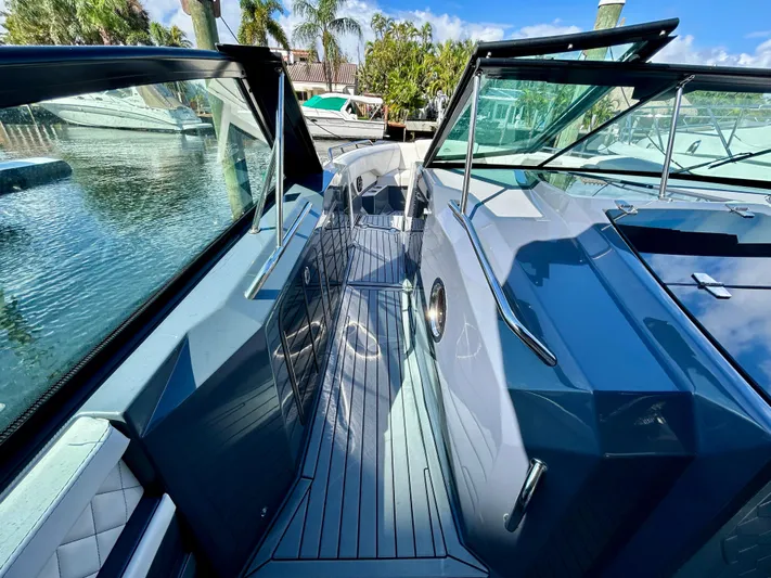 Tgis Yacht Photos Pics 2021 Cruisers Yachts 338 South Beach Edition Bow Rider, sleek design, docked by palm trees.