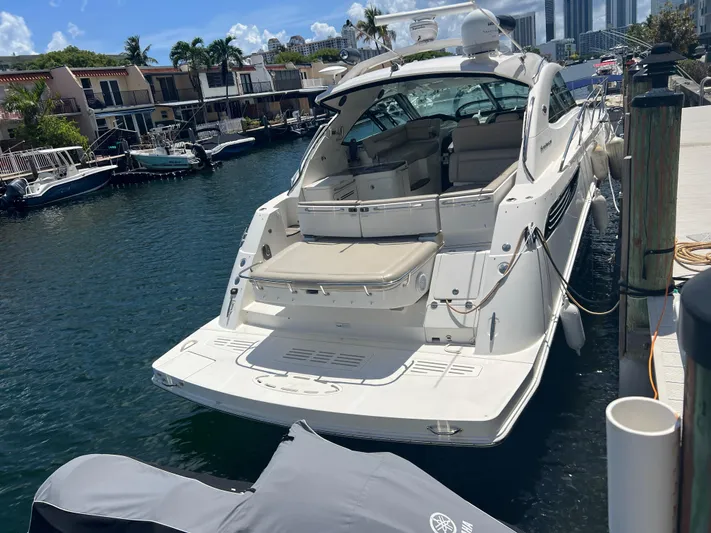  Yacht Photos Pics 2013 Sea Ray 410 Sundancer yacht docked at marina, sunny day, waterfront homes in background.