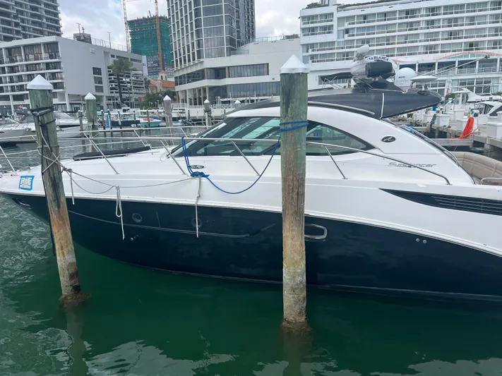  Yacht Photos Pics 2013 Sea Ray 410 Sundancer yacht docked at a marina with modern buildings.