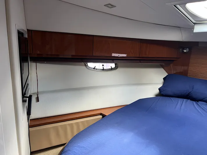  Yacht Photos Pics Interior cabin of 2013 Sea Ray 410 Sundancer yacht with bed and wooden cabinets.