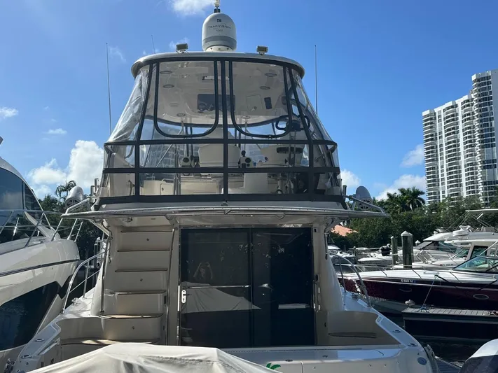Meccabucks Yacht Photos Pics 2007 Sea Ray 52 Sedan Bridge yacht docked at marina, clear sky, modern buildings in background.