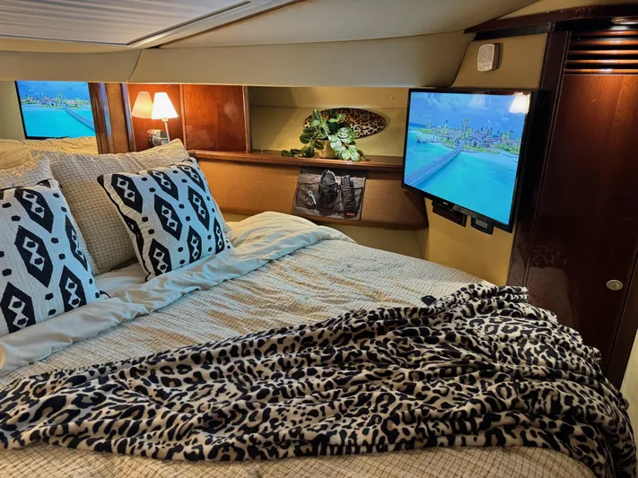 Meccabucks Yacht Photos Pics Luxurious bedroom interior of 2007 Sea Ray 52 Sedan Bridge yacht with TV and stylish decor.