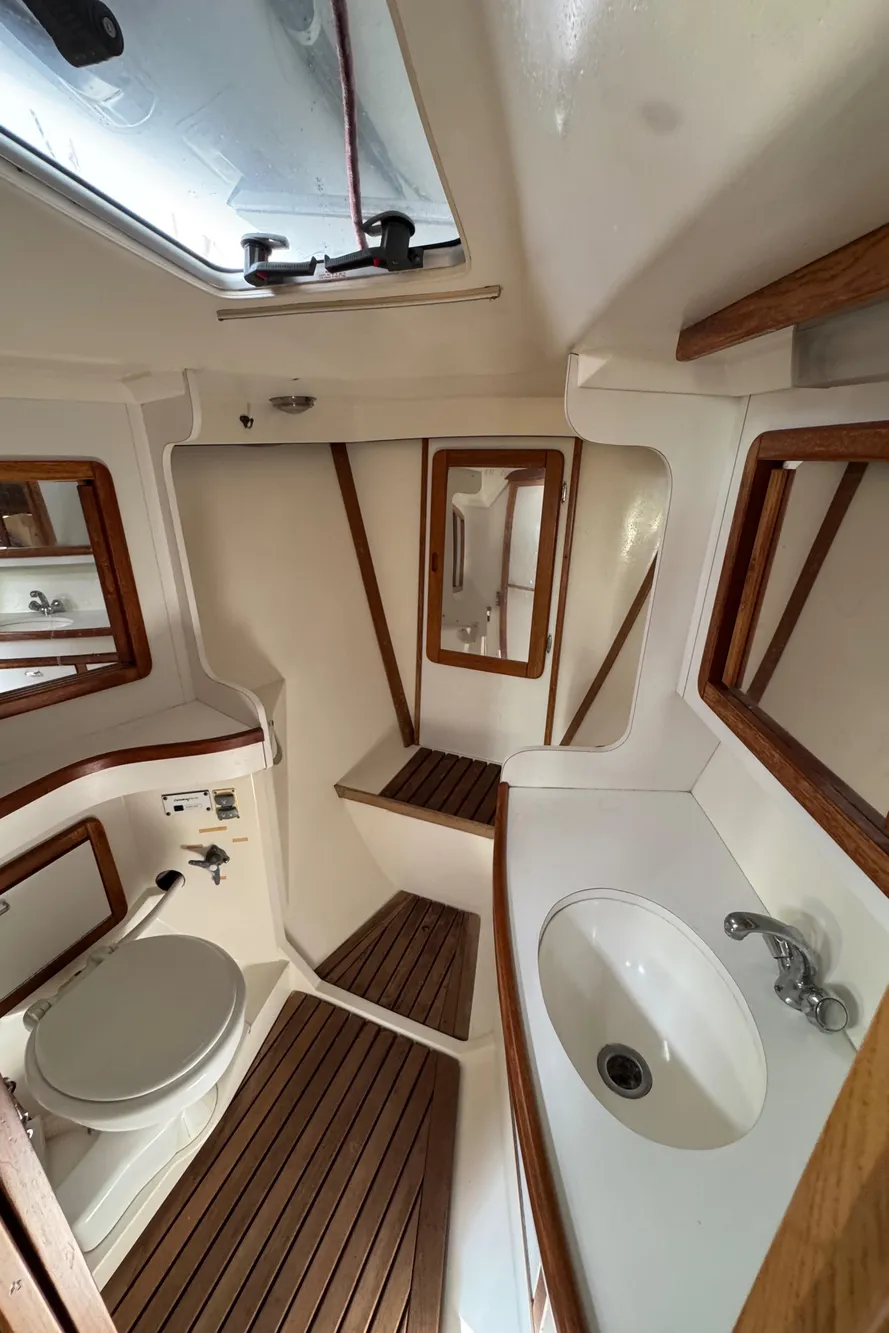Interior of 1993 Catalina 42 sailboat bathroom with wooden accents and white fixtures.