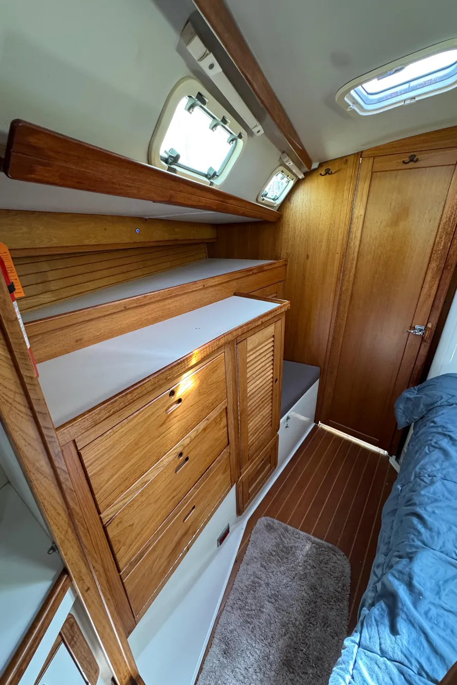 Interior of 1993 Catalina 42 sailboat with wooden cabinetry and cozy sleeping area.