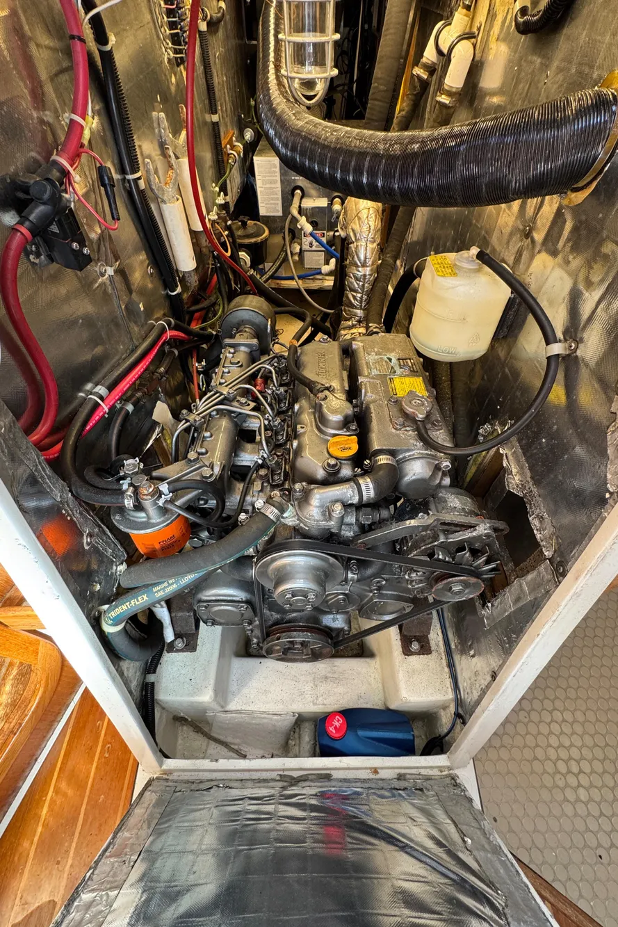 Engine compartment of a 1993 Catalina 42 sailboat, showcasing mechanical components and wiring.