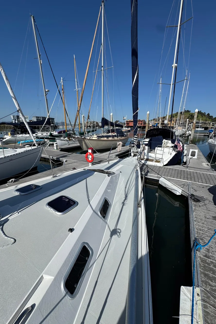 Sailboats docked at marina, featuring a 1993 Catalina 42 under clear blue skies.