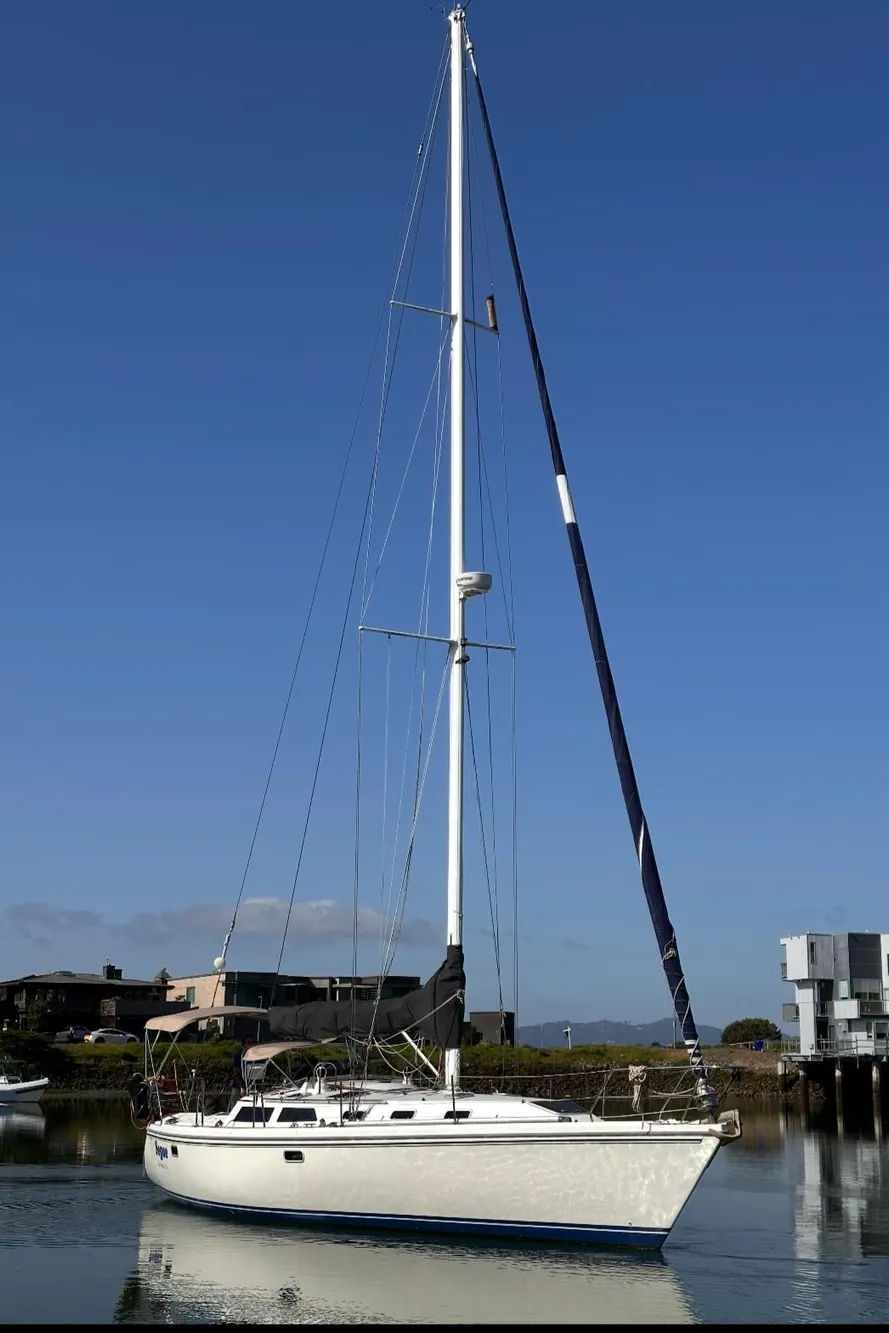Sailboat Catalina 42, 1993 model, docked in a serene marina under clear blue skies.