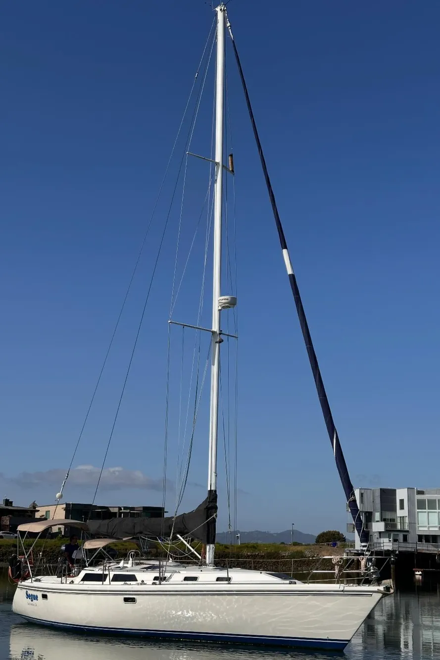 Sailboat Catalina 42, 1993 model, docked on calm water under clear blue sky.