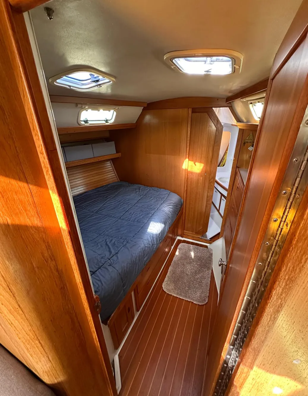 Cozy cabin interior of a 1993 Catalina 42 sailboat with wooden finishes and skylights.