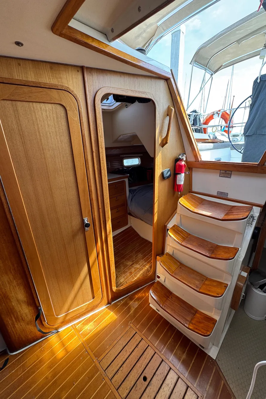 Interior of a 1993 Catalina 42 sailboat with wooden steps and cabin door.
