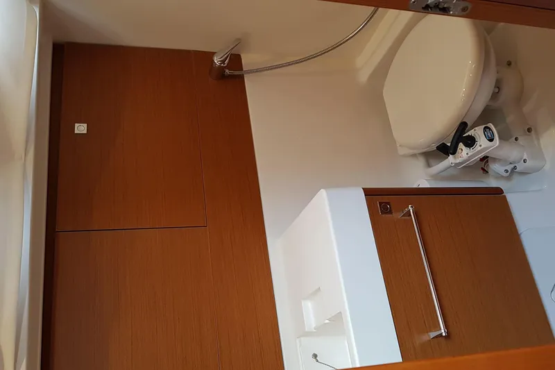 Fiesta Yacht Photos Pics 2019 Jeanneau Sun Odyssey 519 bathroom with wooden cabinetry and compact toilet.