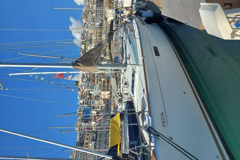 Fiesta Yacht Photos Pics 2019 Jeanneau Sun Odyssey 519 sailboat docked in a vibrant marina.