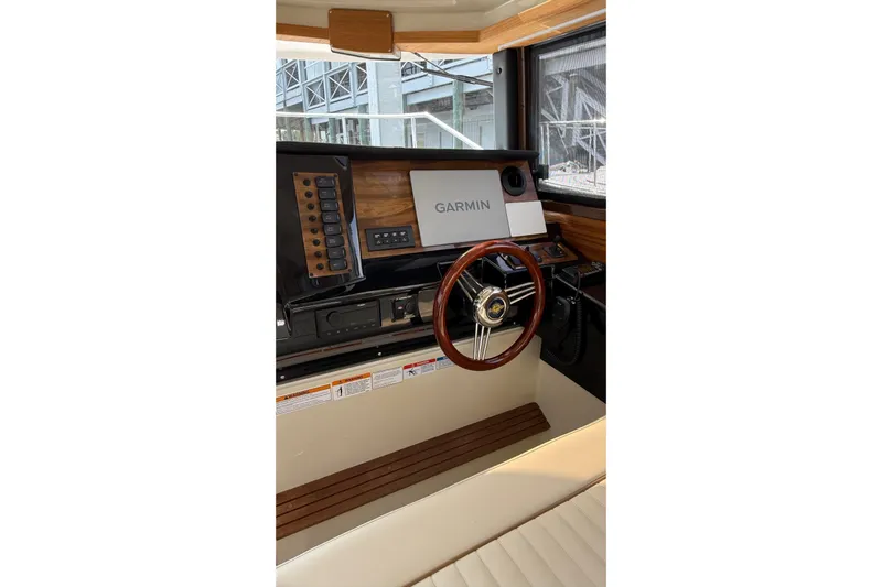  Yacht Photos Pics 2026 Ranger Tugs R-27 helm with Garmin navigation system and wooden steering wheel.