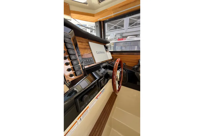  Yacht Photos Pics 2026 Ranger Tugs R-27 helm with Garmin display and wooden steering wheel.