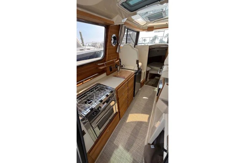  Yacht Photos Pics 2026 Ranger Tugs R-27 interior with modern kitchen and cozy cabin space.