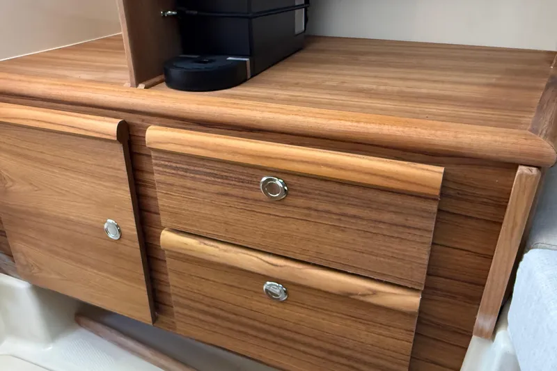  Yacht Photos Pics Wooden cabinetry inside 2026 Ranger Tugs R-27 boat, featuring sleek drawers and modern design.