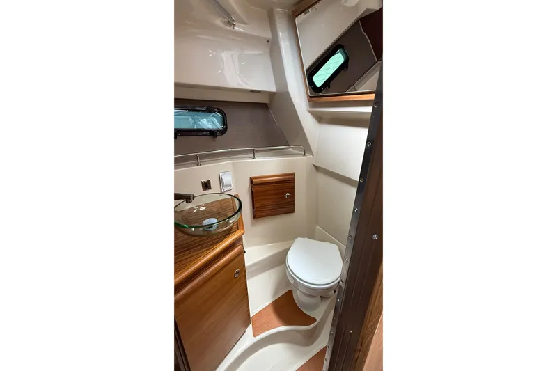  Yacht Photos Pics 2026 Ranger Tugs R-27 boat bathroom with modern fixtures and wood accents.