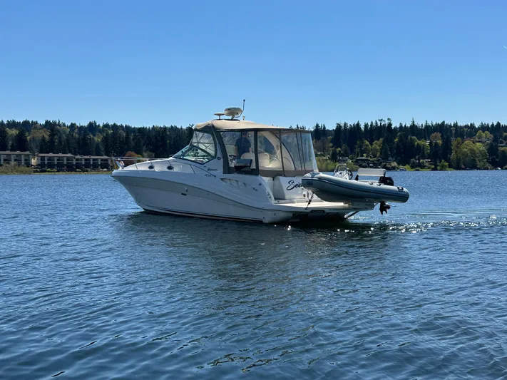  Yacht Photos Pics 2004 Sea Ray 340 Sundancer cruising on a serene lake under a clear blue sky.