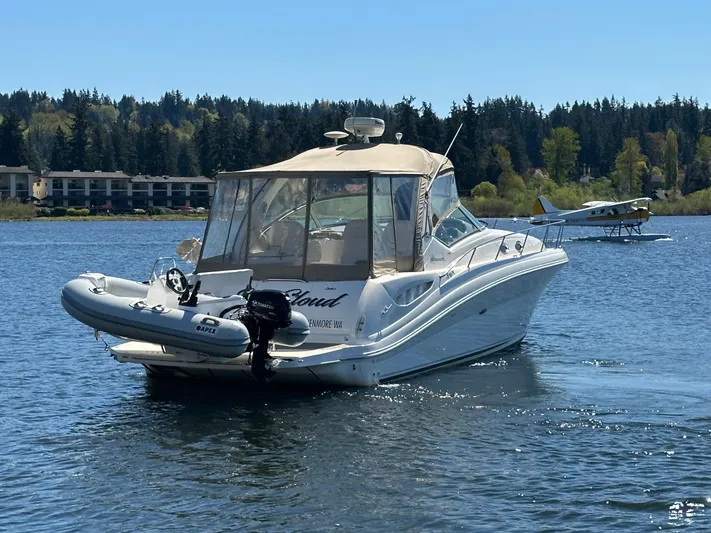  Yacht Photos Pics 2004 Sea Ray 340 Sundancer boat on a lake with a seaplane in the background.
