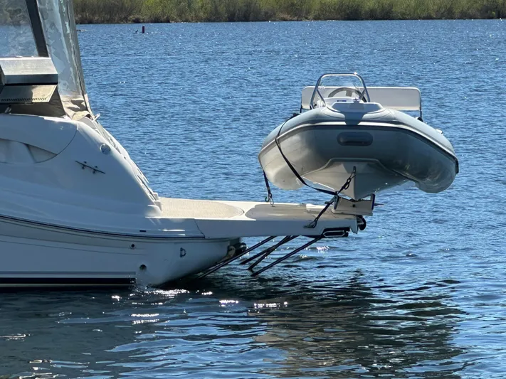  Yacht Photos Pics 2004 Sea Ray 340 Sundancer with dinghy on water, rear view.