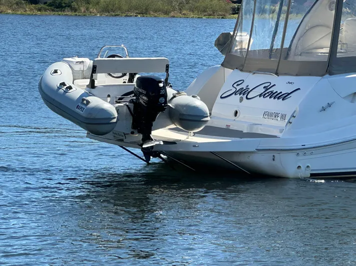  Yacht Photos Pics 2004 Sea Ray 340 Sundancer yacht with attached inflatable boat on calm water.