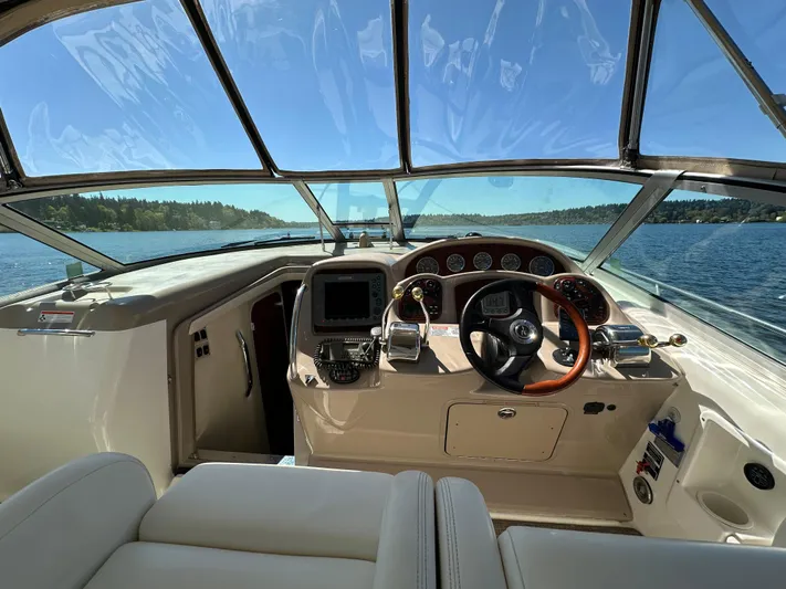  Yacht Photos Pics 2004 Sea Ray 340 Sundancer helm with steering wheel and navigation system on a sunny day.