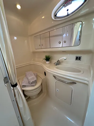  Yacht Photos Pics 2004 Sea Ray 340 Sundancer bathroom with sink, mirror, and porthole window.