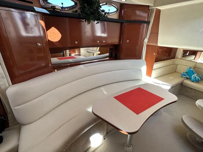  Yacht Photos Pics Luxurious interior of 2004 Sea Ray 340 Sundancer with white seating and wooden cabinetry.