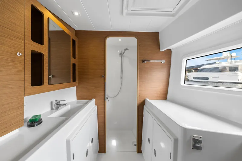 Benedetto Yacht Photos Pics Modern bathroom interior of 2020 Lagoon 42 yacht with shower and wooden accents.