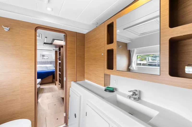 Benedetto Yacht Photos Pics Modern interior of 2020 Lagoon 42 yacht featuring a sleek bathroom and cozy cabin.