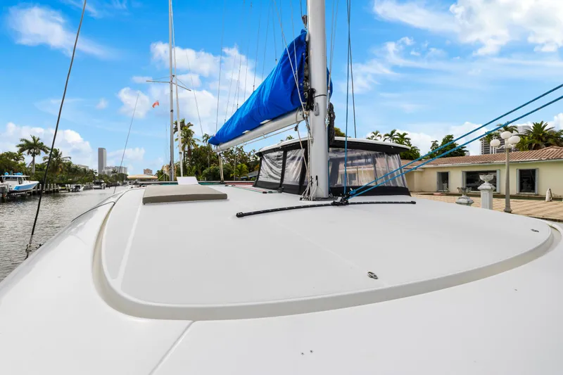 Benedetto Yacht Photos Pics 2020 Lagoon 42 catamaran docked, featuring sleek deck and blue sail under clear sky.
