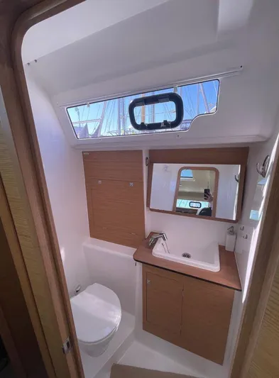 Stellar Yacht Photos Pics 2016 Dufour 460 Grand Large yacht bathroom with modern fixtures and wooden cabinetry.