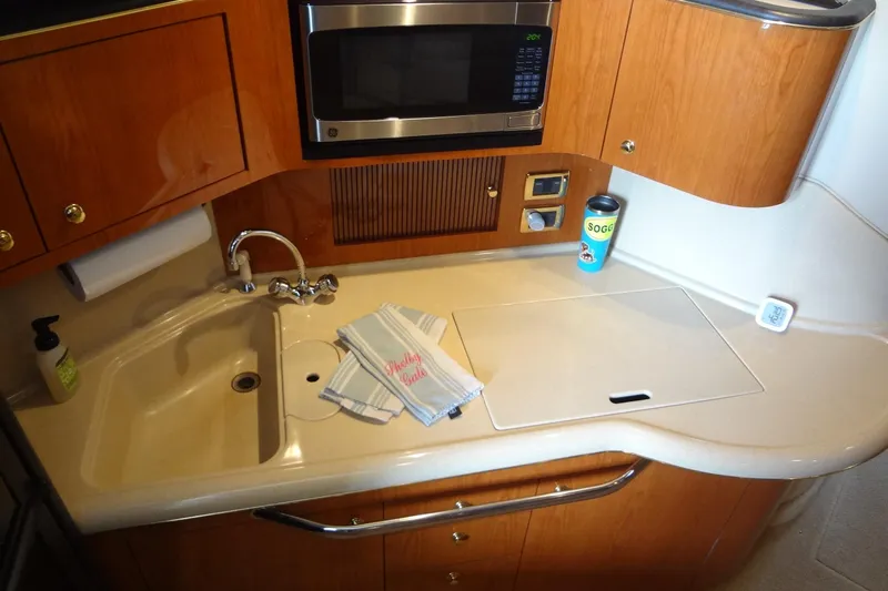 Shel 'b' Gale Yacht Photos Pics 2001 Sea Ray 380 Sundancer kitchen with sink, microwave, and wooden cabinetry.