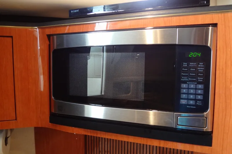 Shel 'b' Gale Yacht Photos Pics Microwave in 2001 Sea Ray 380 Sundancer yacht kitchen, featuring wood cabinetry.
