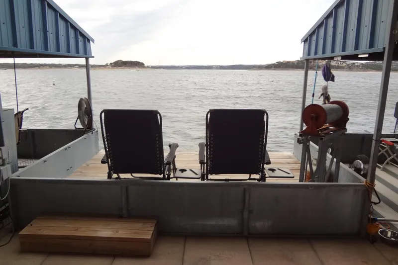 Shel 'b' Gale Yacht Photos Pics Two chairs on a dock overlooking a serene lake view.