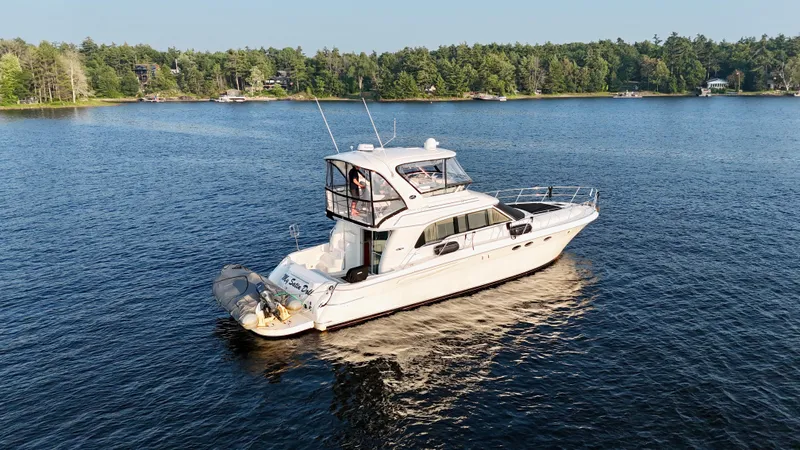 My Satin Doll Yacht Photos Pics 2001 Sea Ray 480 Sedan Bridge yacht cruising on a serene lake.