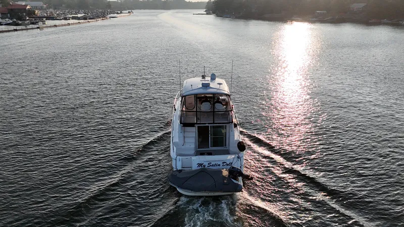 My Satin Doll Yacht Photos Pics 2001 Sea Ray 480 Sedan Bridge yacht cruising on a sunlit river.